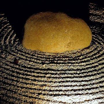 Sandy orbits around a large stone