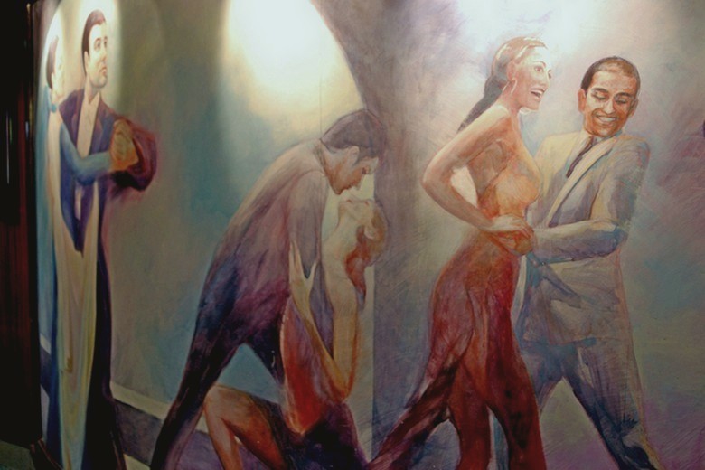 The interior in the form of a dance scenes painted on a wall, at the entrance to the restaurant
